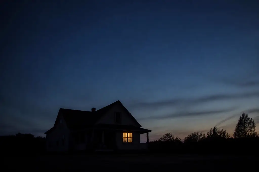 An American house at dusk with one warm window lit